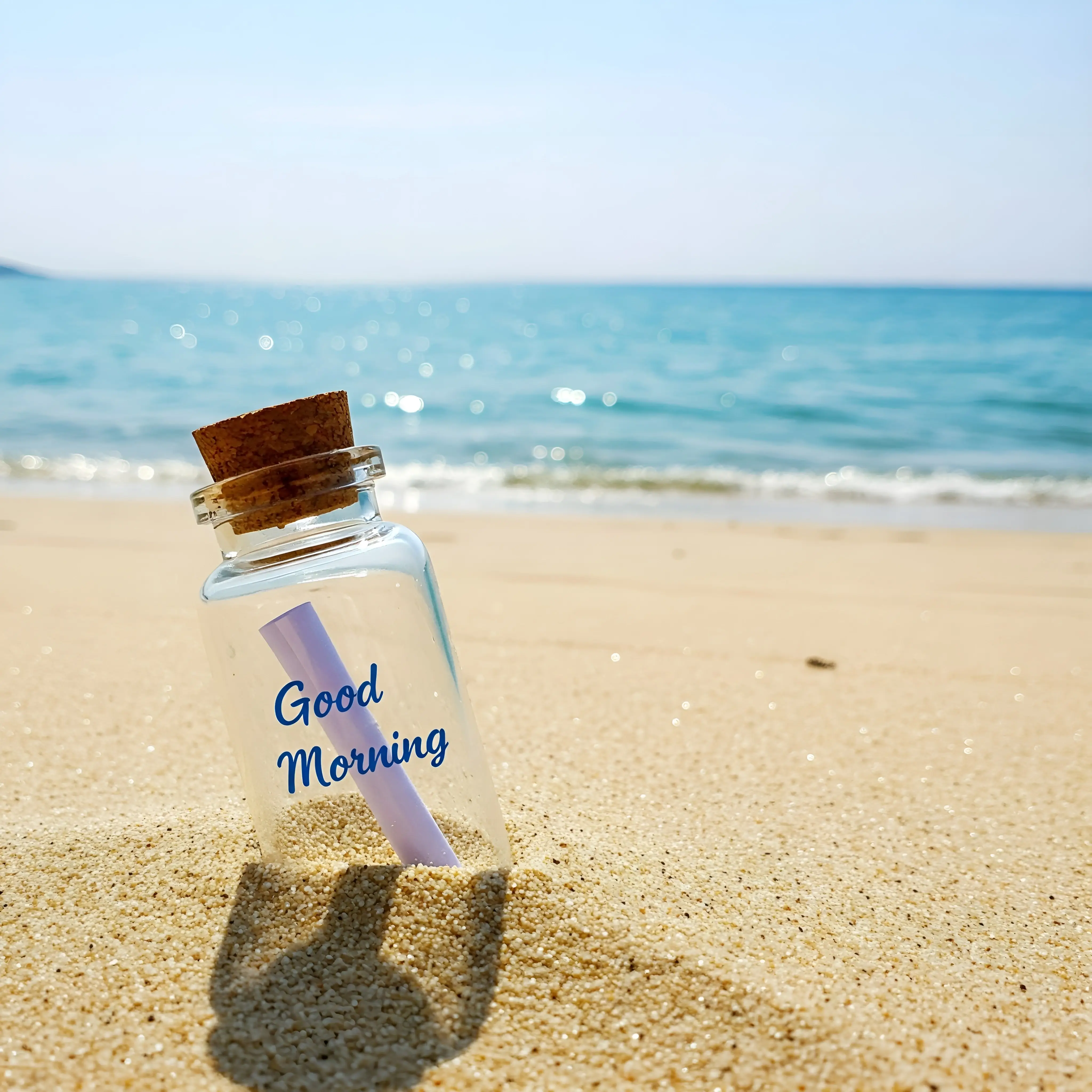 Glass Bottle with 'Good Morning' Message on a Beach Shoreline
