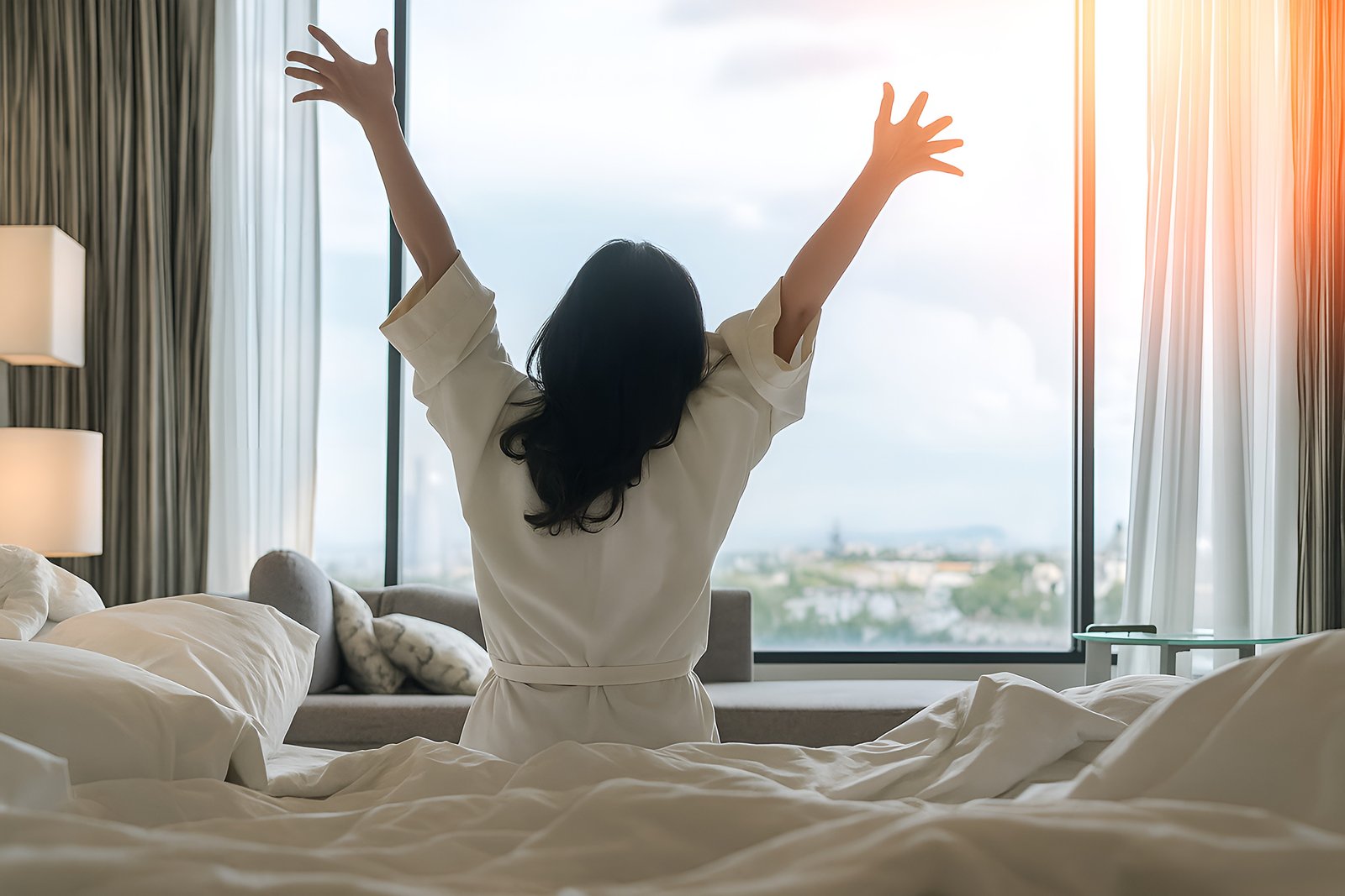 Woman Enjoying Morning Relaxation in Bright Sunlit Room Overlooking City